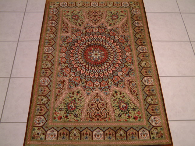 A smaller pure silk Qom rug with the more traditional looking Gombad pattern. As you can see in the colors, there can be a great deal of variety in the color and design combination in these types of Gombad Persian rugs.