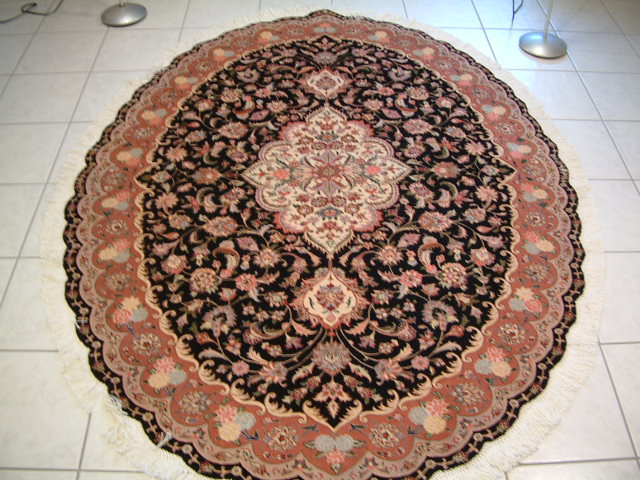 This large oval Tabriz rug was completed in late 2006 and shipped to me shortly after. I am always very cautious about the oval Persian rugs due to the possibilities of them being slightly off center, which can make the design and shape look very bad. This particular oval Tabriz carpet is extremely well made and I was very pleased to see the quality of the rug as well as the obvious skill of the carpet weaver. There are lots of silk highlights in this oval Tabriz rug and it is designed to be a showpiece and also to be very durable.